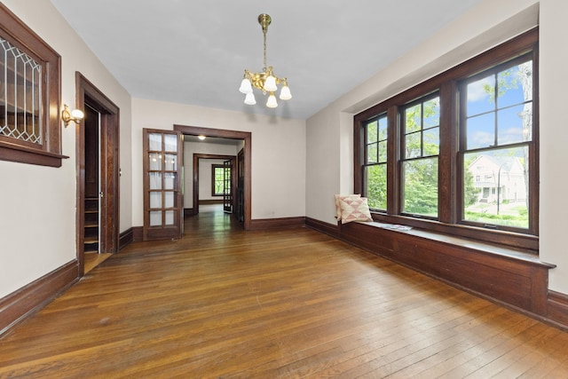 1706 S University Ave, Ann Arbor, MI 48104 - spare room with hardwood / wood-style flooring, a chandelier, baseboards, and french doors