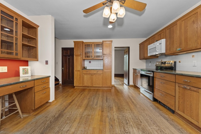 1706 S University Ave, Ann Arbor, MI 48104 - kitchen featuring white microwave, stainless steel range with electric cooktop, wood finished floors, decorative backsplash, and ceiling fan