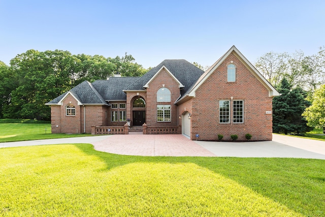 4297 Upper Glade Ct, Ann Arbor, MI 48103 - traditional-style home featuring brick siding, a front lawn, roof with shingles, and concrete driveway