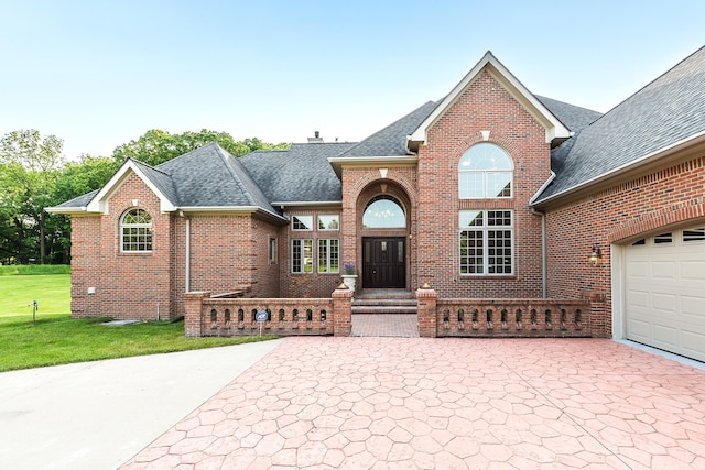 4297 Upper Glade Ct, Ann Arbor, MI 48103 - traditional-style house with a shingled roof, brick siding, a front yard, and driveway