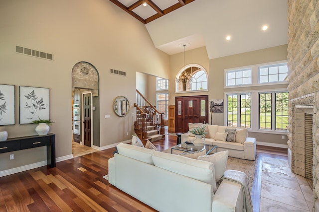 4297 Upper Glade Ct, Ann Arbor, MI 48103 - living room with high vaulted ceiling, wood finished floors, stairway, baseboards, and a large fireplace