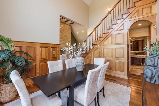4297 Upper Glade Ct, Ann Arbor, MI 48103 - dining area featuring high vaulted ceiling, stairs, wood finished floors, arched walkways, and recessed lighting