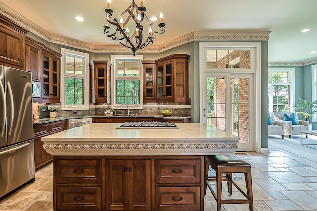 4297 Upper Glade Ct, Ann Arbor, MI 48103 - kitchen with appliances with stainless steel finishes, ornamental molding, decorative backsplash, a chandelier, and stone tile flooring