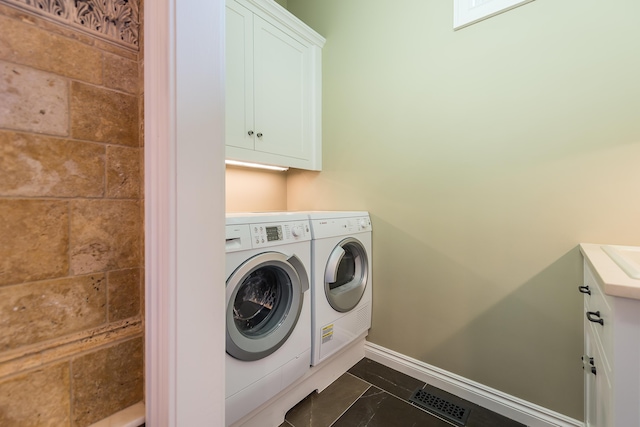 4297 Upper Glade Ct, Ann Arbor, MI 48103 - laundry area featuring washer and dryer, cabinet space, and baseboards