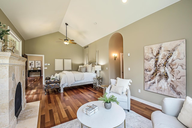 4297 Upper Glade Ct, Ann Arbor, MI 48103 - bedroom featuring arched walkways, wood finished floors, a tiled fireplace, baseboards, and ceiling fan