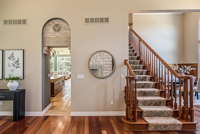 4297 Upper Glade Ct, Ann Arbor, MI 48103 - stairway with baseboards, wood finished floors, and a chandelier