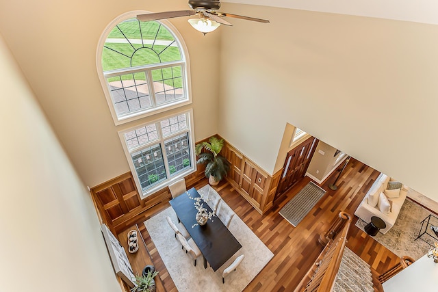 4297 Upper Glade Ct, Ann Arbor, MI 48103 - living room with a towering ceiling, wood finished floors, wainscoting, and a ceiling fan