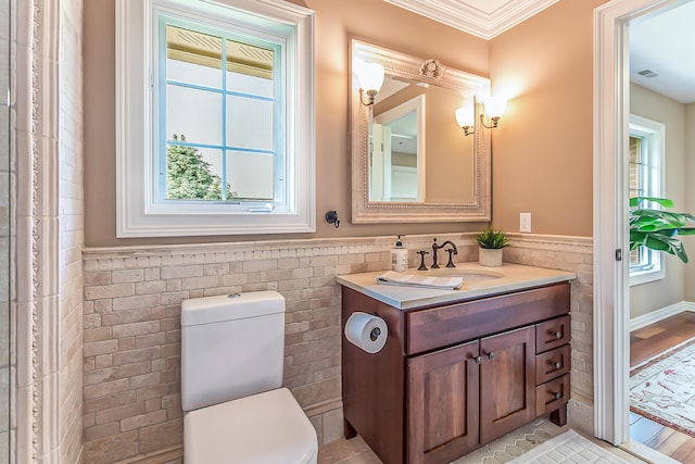 4297 Upper Glade Ct, Ann Arbor, MI 48103 - bathroom featuring tile walls, wainscoting, vanity, toilet, and ornamental molding