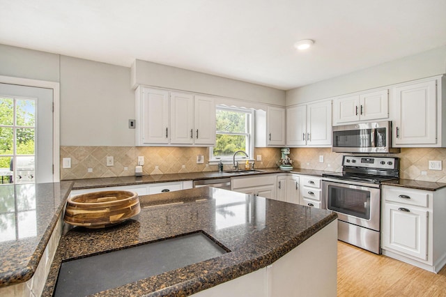 5616 Stoney Brook Rd, Kalamazoo, MI 49009 - kitchen featuring appliances with stainless steel finishes, a sink, dark stone counters, and white cabinetry