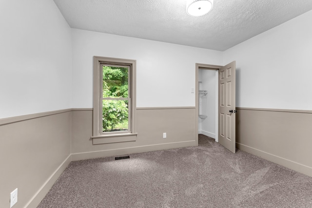 925 133rd Ave, Wayland, MI 49348 - unfurnished bedroom featuring carpet floors, a textured ceiling, baseboards, and a walk in closet