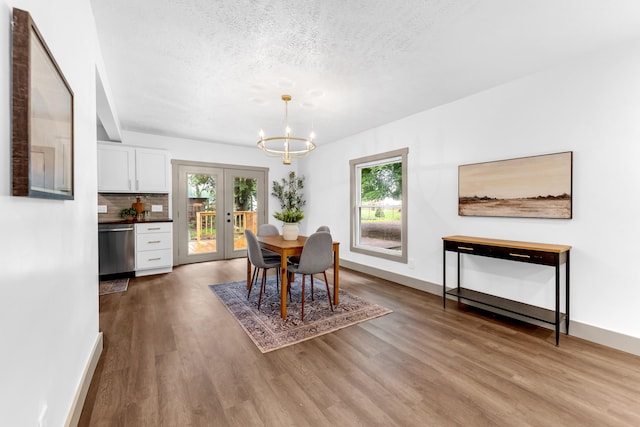 925 133rd Ave, Wayland, MI 49348 - dining space featuring french doors, a chandelier, wood finished floors, baseboards, and a textured ceiling