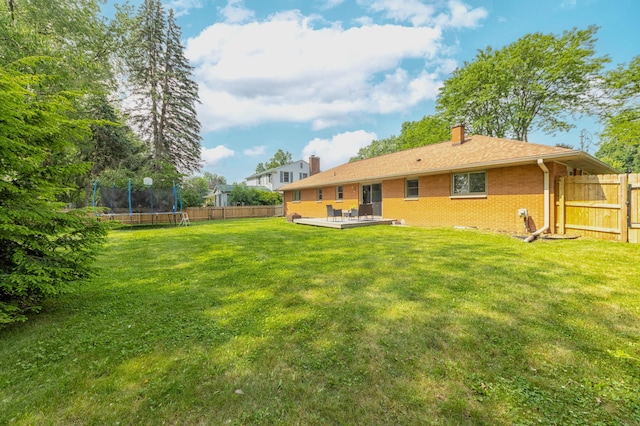 1110 Piccadilly Rd, Kalamazoo, MI 49006 - rear view of property with a chimney, a trampoline, brick siding, and a wooden deck