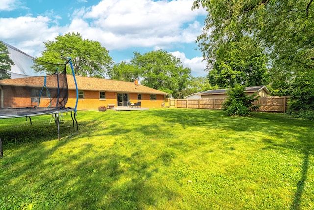 1110 Piccadilly Rd, Kalamazoo, MI 49006 - view of yard featuring a trampoline and a deck