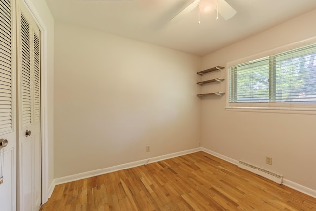 1110 Piccadilly Rd, Kalamazoo, MI 49006 - unfurnished bedroom with a baseboard radiator, a closet, light wood-style floors, and baseboards