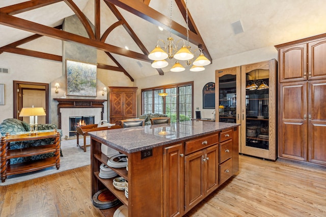 6242 131st Ave, Saugatuck, MI 49453 - kitchen featuring open shelves, high vaulted ceiling, light wood finished floors, a glass covered fireplace, and beamed ceiling