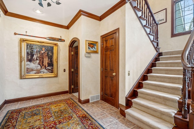 6242 131st Ave, Saugatuck, MI 49453 - foyer entrance featuring arched walkways, ornamental molding, stairs, and baseboards