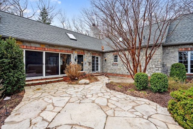 6242 131st Ave, Saugatuck, MI 49453 - back of property with a patio, stone siding, a chimney, and a sunroom