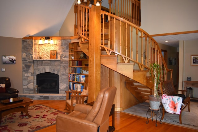 226 N 176th Ave, Walkerville, MI 49459 - living room with wood finished floors, a fireplace, stairway, and high vaulted ceiling