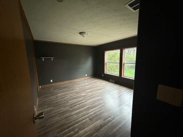 212 Cass St, Mio, MI 48647 - spare room featuring a textured ceiling, wood finished floors, baseboards, and crown molding