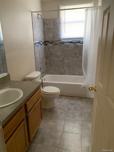 319 S Anderson Ave, Southfield, MI 48342 - full bath featuring vanity, shower / bath combo with shower curtain, toilet, and tile patterned flooring