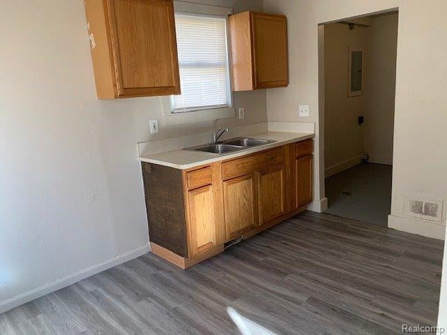 319 S Anderson Ave, Southfield, MI 48342 - kitchen with a sink, wood finished floors, brown cabinets, light countertops, and baseboards