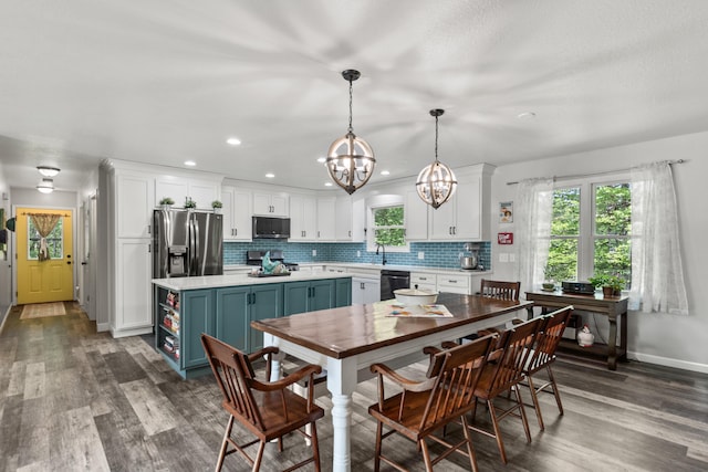 2980 N Old State Rd, Weidman, MI 48893 - kitchen with appliances with stainless steel finishes, white cabinetry, light countertops, a chandelier, and healthy amount of natural light