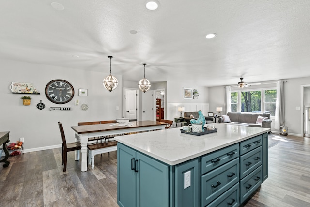 2980 N Old State Rd, Weidman, MI 48893 - kitchen with a kitchen island, dark wood finished floors, baseboards, open floor plan, and a ceiling fan