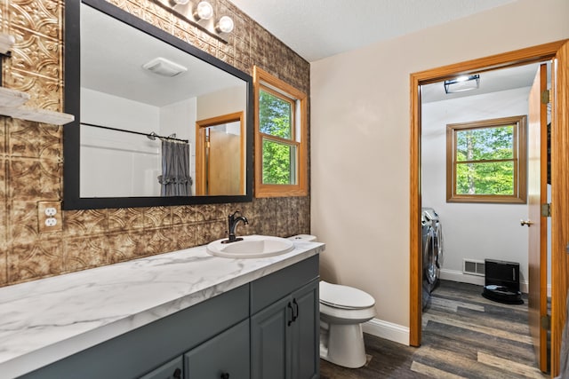 2980 N Old State Rd, Weidman, MI 48893 - full bathroom with washing machine and clothes dryer, vanity, wood finished floors, and plenty of natural light