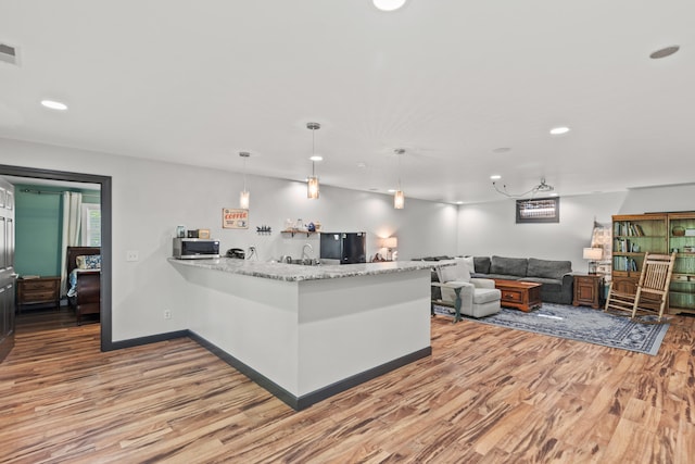 2980 N Old State Rd, Weidman, MI 48893 - kitchen featuring freestanding refrigerator, light wood-style flooring, light stone countertops, and recessed lighting