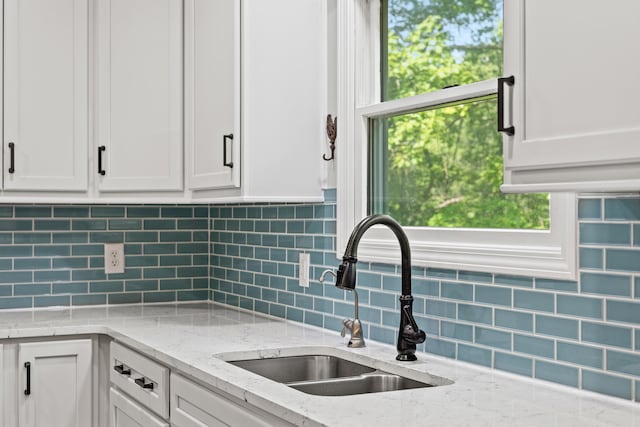 2980 N Old State Rd, Weidman, MI 48893 - kitchen featuring a sink, white cabinets, tasteful backsplash, and light stone countertops