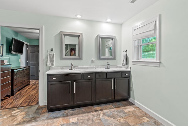 2980 N Old State Rd, Weidman, MI 48893 - bathroom featuring baseboards, double vanity, and stone finish floors