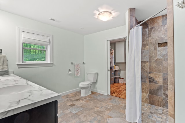 2980 N Old State Rd, Weidman, MI 48893 - full bath featuring vanity, toilet, stone finish floors, tiled shower, and baseboards