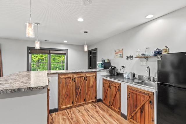 2980 N Old State Rd, Weidman, MI 48893 - kitchen featuring freestanding refrigerator, a sink, light wood finished floors, brown cabinetry, and stainless steel microwave