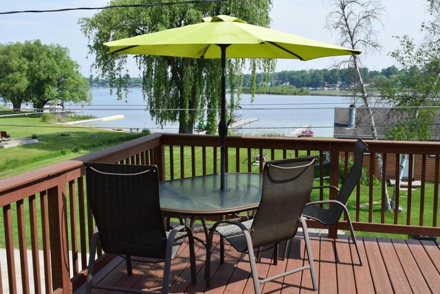 1034 Thompson St SW, Stanton, MI 48888 - wooden deck featuring outdoor dining space, a water view, and a lawn