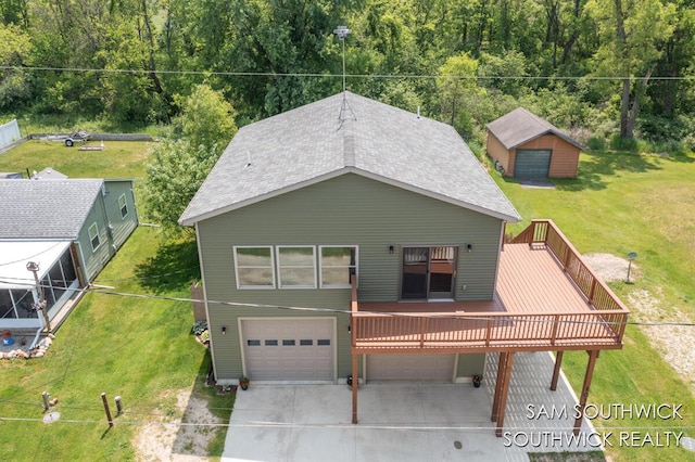 1034 Thompson St SW, Stanton, MI 48888 - back of house with a garage, a deck, driveway, a lawn, and a shingled roof