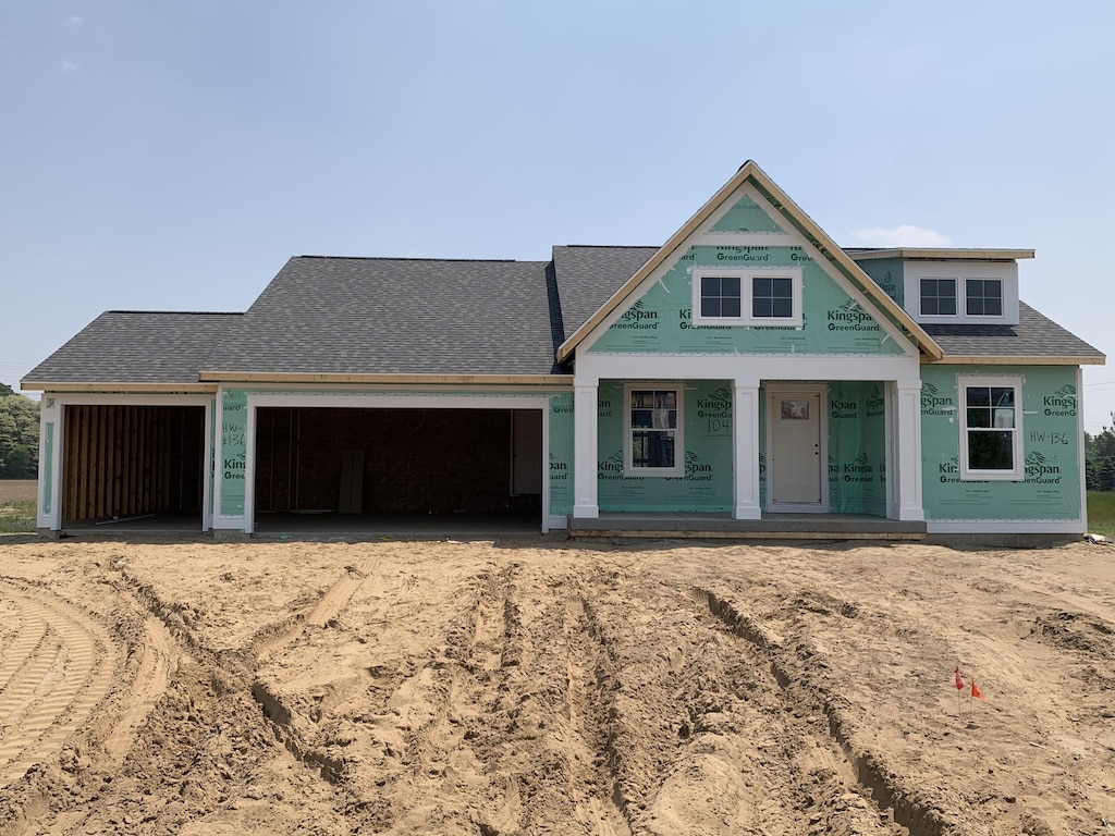 10448 Poppy Ln, Allendale, MI 49401 - unfinished property featuring dirt driveway, a garage, a shingled roof, and covered porch