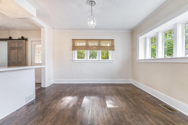 1032 Lafayette Ave NE, Grand Rapids, MI 49503 - unfurnished dining area featuring healthy amount of natural light, dark wood finished floors, baseboards, a barn door, and ornamental molding