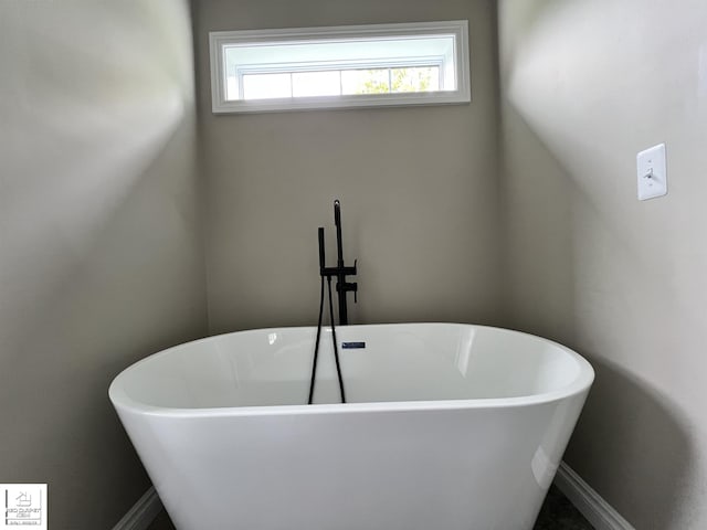3801 Sutton Rd, Metamora, MI 48455 - bathroom with a freestanding bath and baseboards