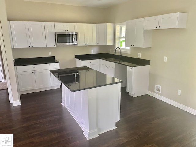 3801 Sutton Rd, Metamora, MI 48455 - kitchen featuring stainless steel microwave, dark wood-style flooring, baseboards, and white cabinetry