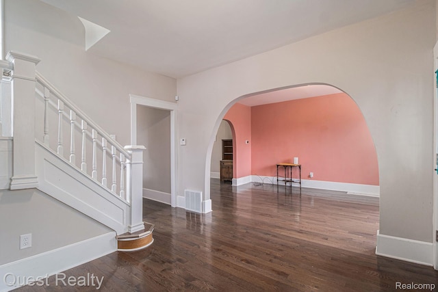 2499 Baldwin St, Detroit, MI 48214 - empty room featuring wood finished floors, arched walkways, baseboards, and stairs