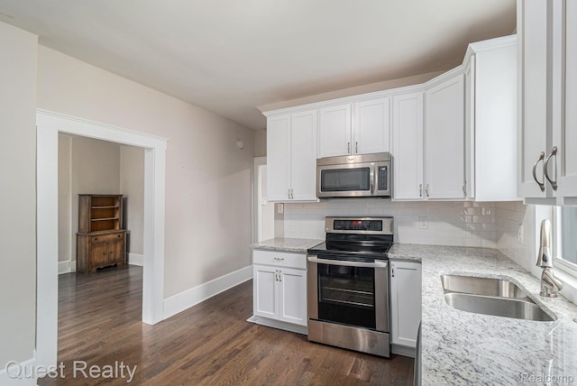 2499 Baldwin St, Detroit, MI 48214 - kitchen featuring stainless steel appliances, a sink, backsplash, baseboards, and light stone countertops
