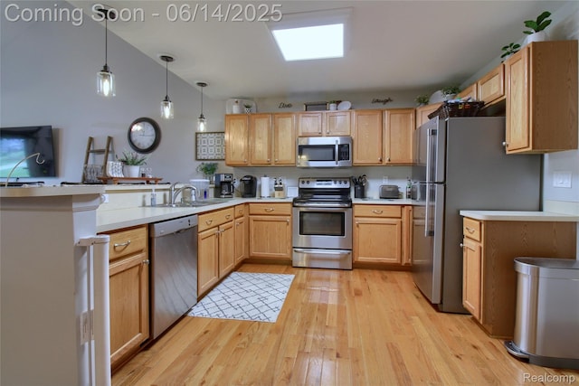 31626 Beaver Cir, New Boston, MI 48164 - kitchen with appliances with stainless steel finishes, a peninsula, light wood-style flooring, light countertops, and decorative light fixtures