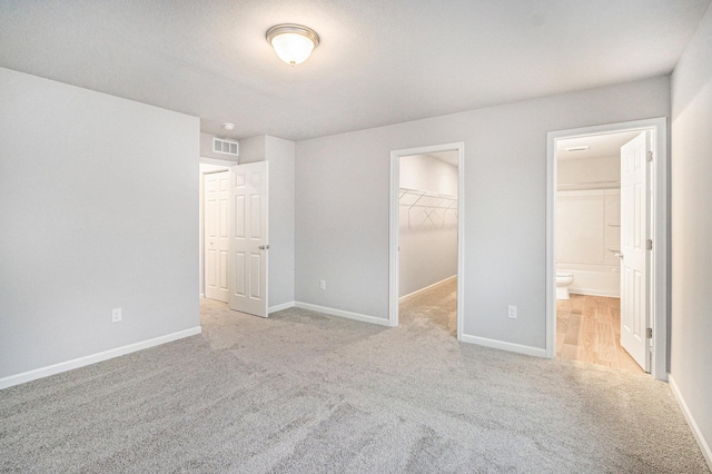 608 Arizona Blvd, Three Rivers, MI 49093 - unfurnished bedroom with carpet, a spacious closet, ensuite bath, a closet, and baseboards
