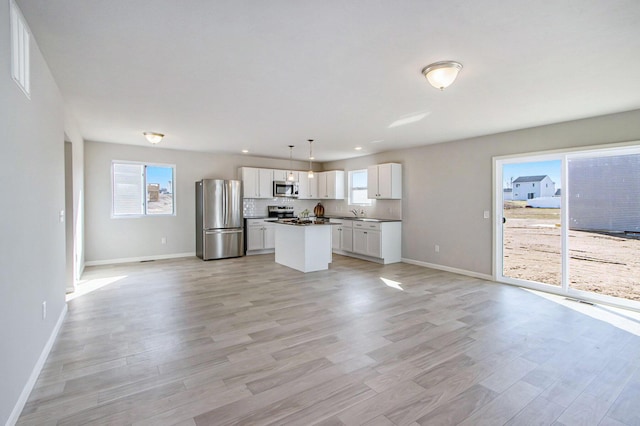 608 Arizona Blvd, Three Rivers, MI 49093 - kitchen with appliances with stainless steel finishes, open floor plan, baseboards, white cabinetry, and dark countertops