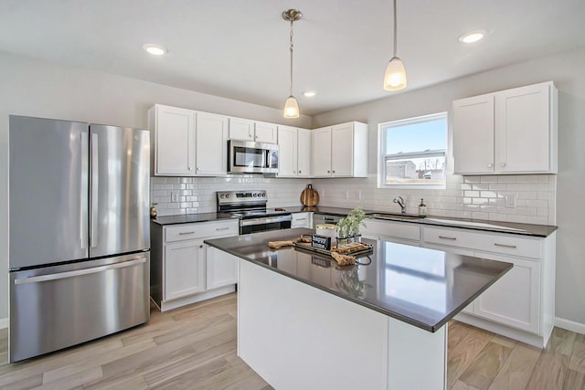 608 Arizona Blvd, Three Rivers, MI 49093 - kitchen featuring stainless steel appliances, dark countertops, a sink, white cabinetry, and decorative backsplash