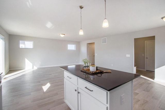 608 Arizona Blvd, Three Rivers, MI 49093 - kitchen featuring dark countertops, light wood-type flooring, healthy amount of natural light, and white cabinetry