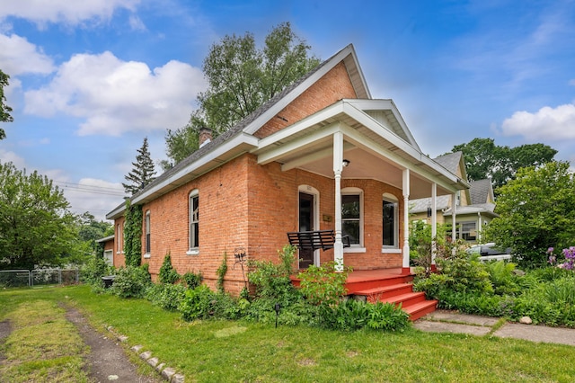 920 Wisconsin Ave, Saint Joseph, MI 49085 - view of front of house with brick siding, covered porch, and a chimney