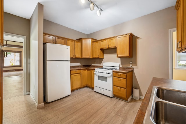 920 Wisconsin Ave, Saint Joseph, MI 49085 - kitchen featuring white appliances, light wood finished floors, healthy amount of natural light, and dark countertops