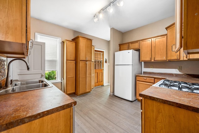 920 Wisconsin Ave, Saint Joseph, MI 49085 - kitchen featuring freestanding refrigerator, a sink, light wood-type flooring, brown cabinetry, and dark countertops
