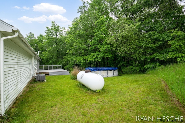 5181 Scotch Mist Dr, Saranac, MI 48881 - view of grassy yard featuring a wooden deck, a covered pool, and central air condition unit
